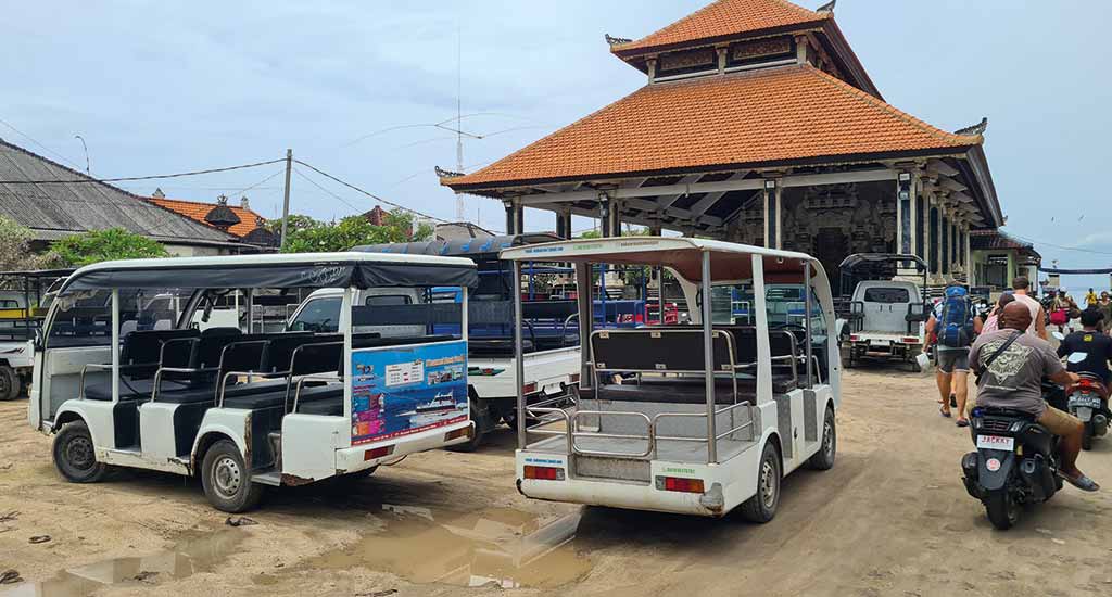 Golf buggies and motorbikes waiting at the port in Nusa Lembongan