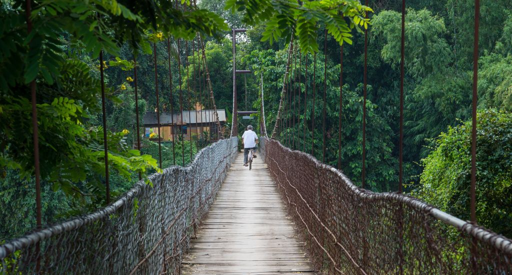 A man riding a bike in a bridge in Battambang