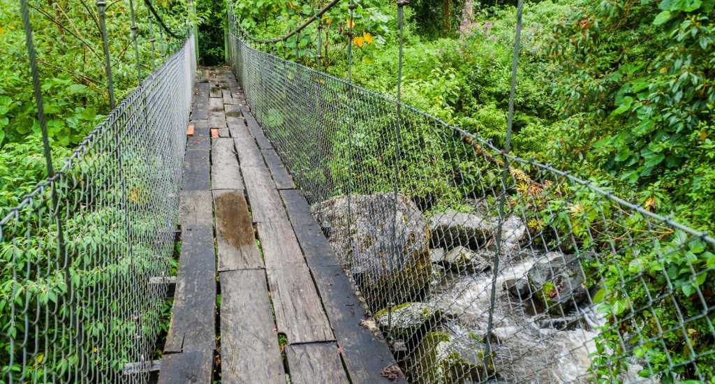 Old wooden suspension bridge in Senderos Los Quetzales trail