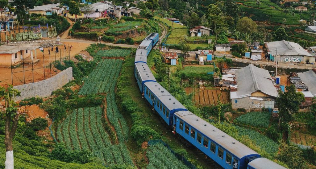 Blue train going through countryside
