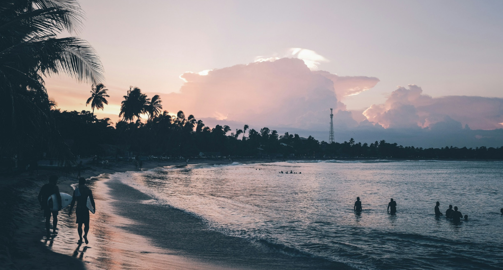 Surfers walking by the beach in Arugam Bay