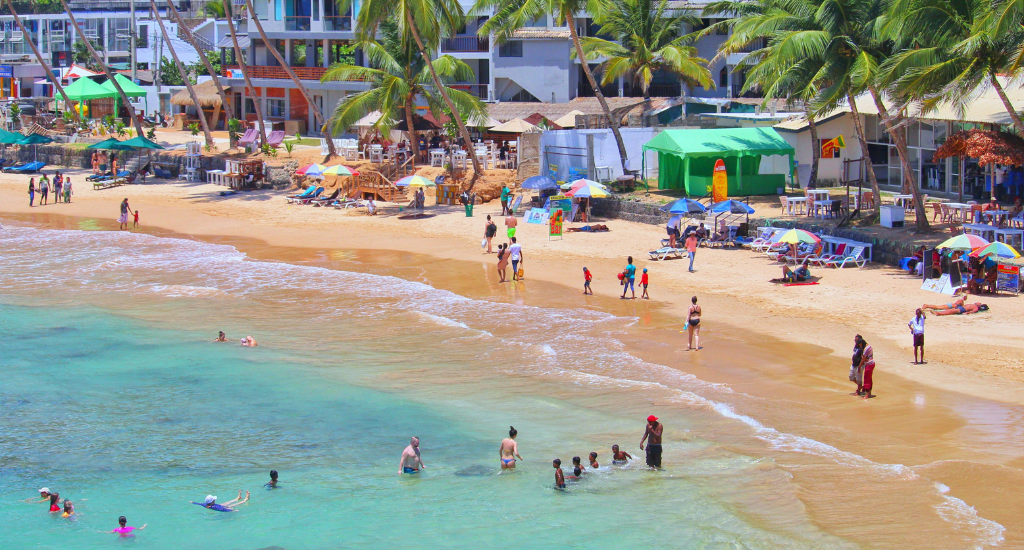 People swimming in the turquoise waters of Mirissa Beach